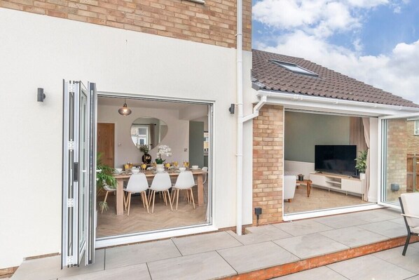 Een modern huis met een eetgedeelte, een tv-kamer en een terras.