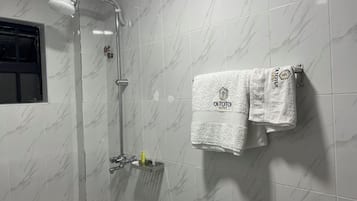 Douche, douche à « effet pluie », chaussons, serviettes fournies