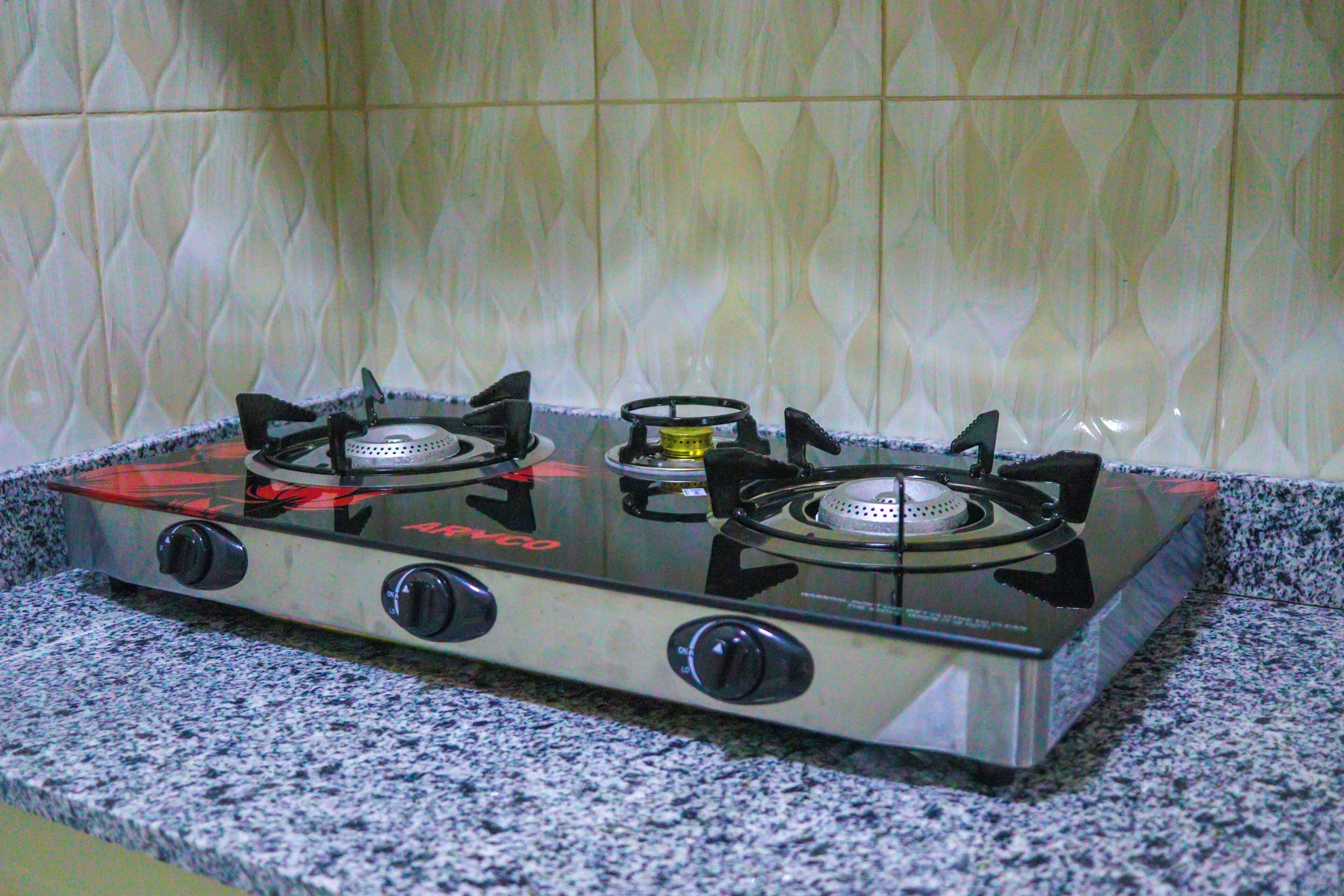 A gas stove with four burners and a control panel, set on a granite countertop.