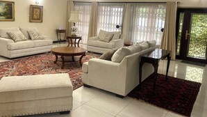 A living room with two sofas, a coffee table, a patterned rug, and a chandelier.