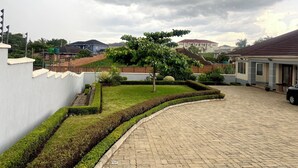 A paved driveway leading to a building with a white exterior and a red roof.