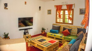Una sala de estar acogedora con un sofá de madera, un televisor y una mesa de centro.