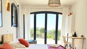 Une chambre moderne avec deux lits, un bureau et une vue sur la verdure.