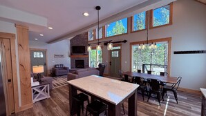 A spacious living area with a fireplace, a dining table, and multiple seating options.