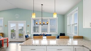 A kitchen with a large island, white cabinets, and a chandelier. - The Turquoise Turtle -Private Pool, Hot Tub, Ocean View, 2nd Row, 4BR, Kids Area (Carolina Beach)