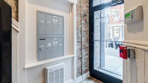 A modern interior with a brick wall, a glass door, and a fire alarm. - Modern Condo in the heart of Over-The-Rhine (Cincinnati)