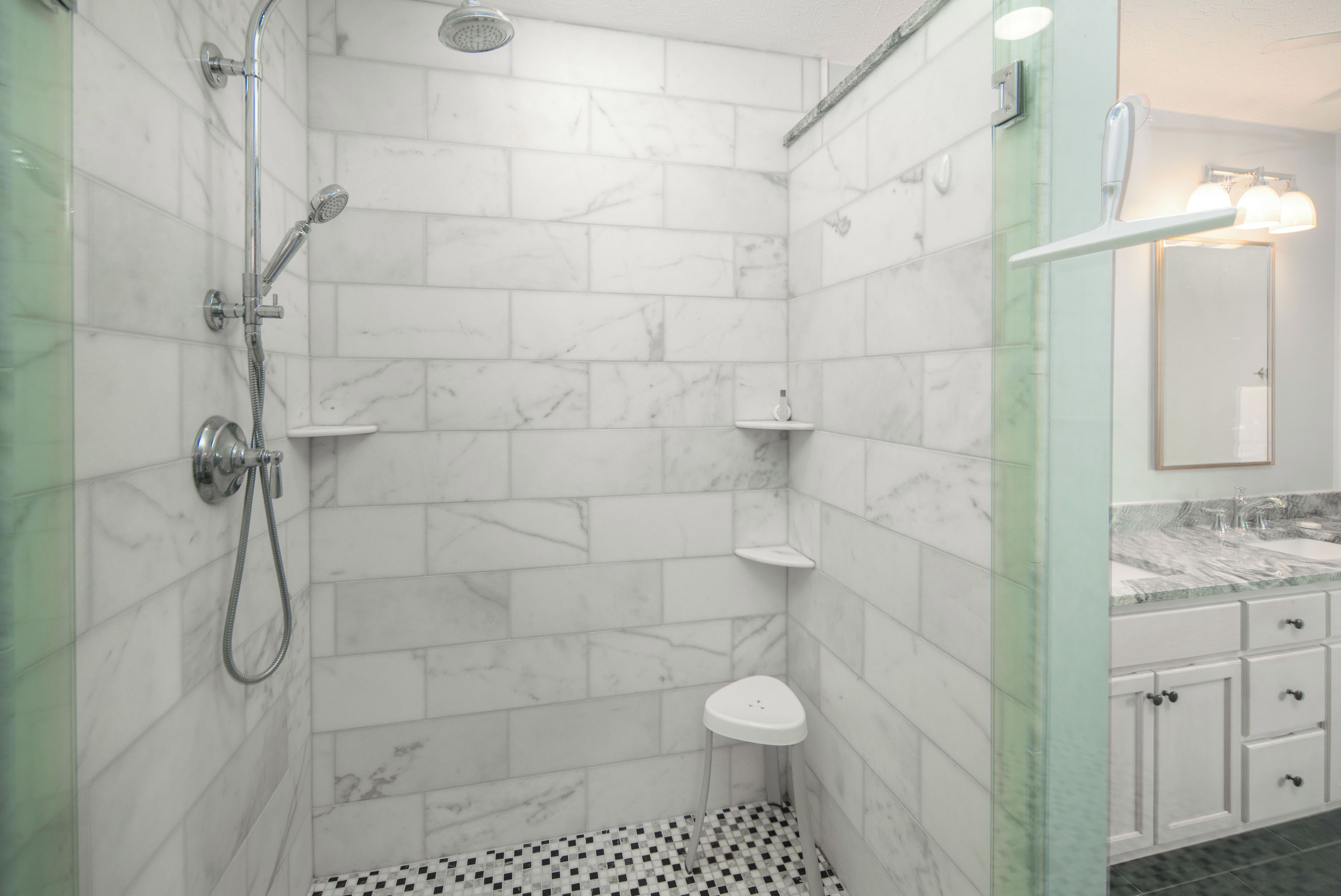 A bathroom with a shower, toilet, and vanity with a mirror.