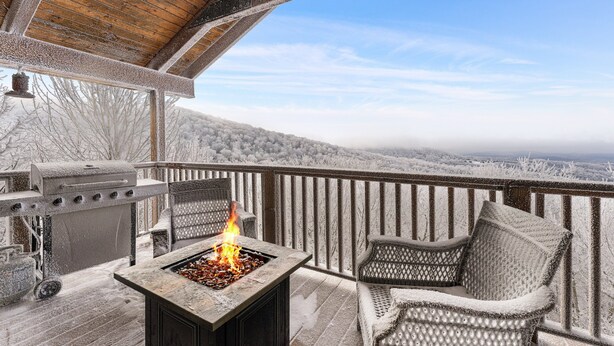 A covered outdoor area with a stone fire pit, a grill, and wicker furniture. - 5,000ft Peak View Home: Hot Tub, Fire Table & 4 Kings; 5 Min to Resort (Beech Mountain)
