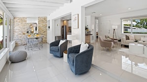 Amplia sala de estar con cocina moderna, comedor y zona de estar con sofás y una mesa de centro.