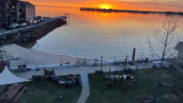 Une propriété située au bord de l’eau, dotée d’un quai, d’un espace extérieur aménagé et offrant une vue sur le coucher de soleil sur l’eau.