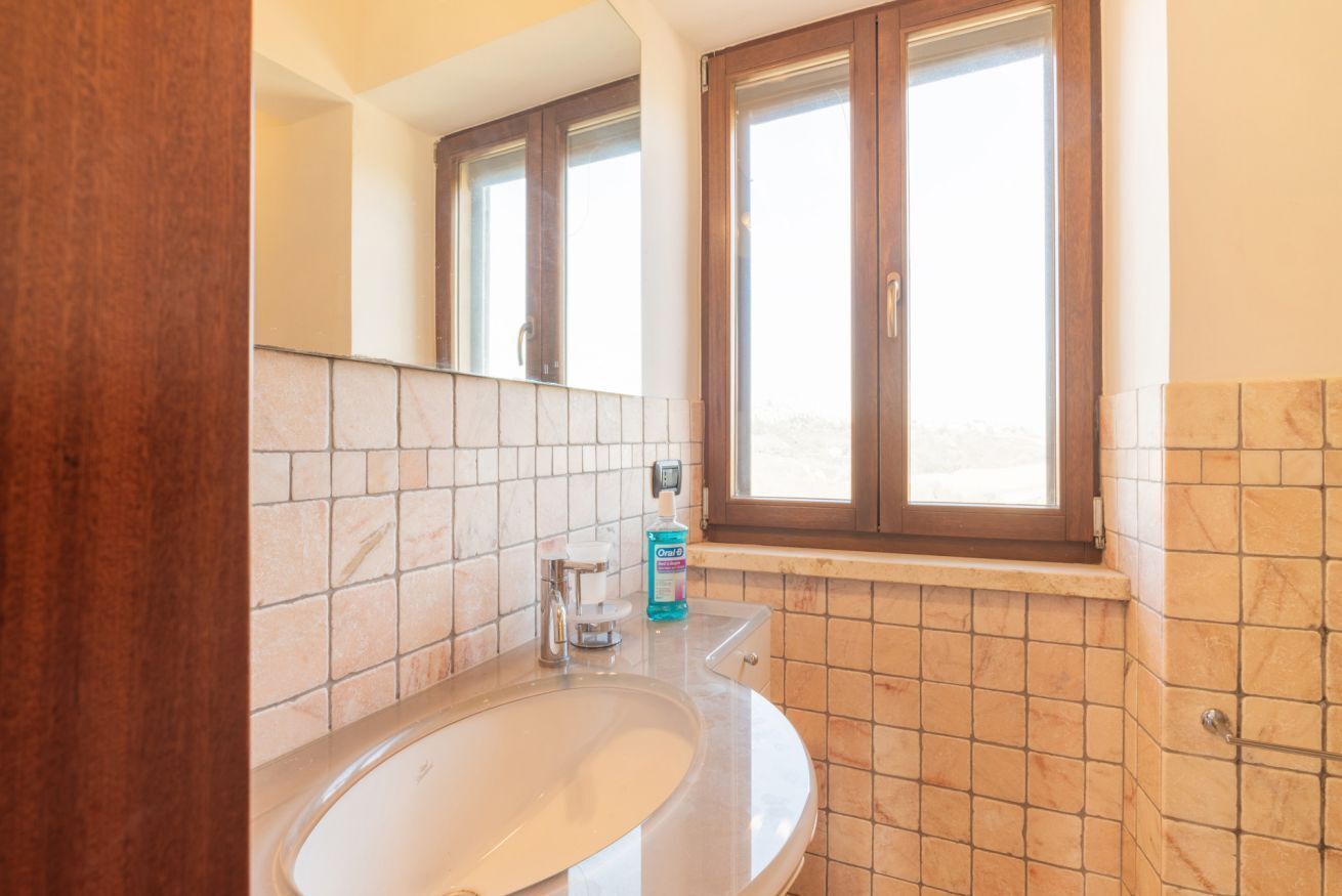 Ein Badezimmer mit Waschbecken, Spiegel und Fenster.