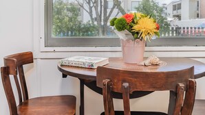 A round wooden table with a potted plant and a book titled "The Art of Wellbeing" on it. - Cozy Pet Friendly Beach House (Kingscliff)