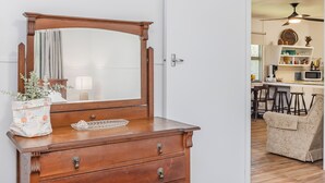 A wooden dresser with a mirror, a potted plant, and a tray. - Cozy Pet Friendly Beach House (Kingscliff)