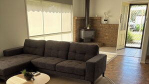 Una sala de estar con un sofá modular, una mesa de centro redonda y una chimenea.