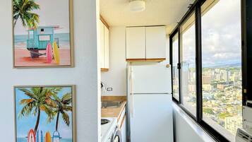 A narrow kitchen with a view of a cityscape.