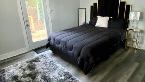Un dormitorio con cama, alfombra, puerta y ventilador de techo.