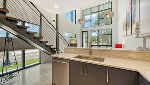 Una cocina moderna con un amplio ventanal, una escalera y vistas al exterior.