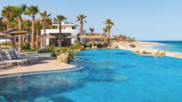A resort pool with clear blue water, surrounded by palm trees and lounge chairs. - NEW! Chic resort in perfect San José del Cabo with fitness room (San José del Cabo)