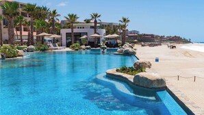A resort pool with a beach view, surrounded by palm trees and lounge chairs. - NEW! Chic resort in perfect San José del Cabo with fitness room (San José del Cabo)