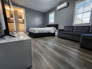 Un dormitorio moderno con cama, sofá y escritorio.