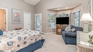 A bedroom with a bed, a television, a sofa, and a window with a view. - 7028 Ocean Lakes Golf Cart⛱️🏝️🩱🌊👙☀️🐚 (Myrtle Beach)