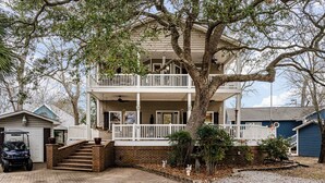 A two-story house with a balcony, a garage, and a driveway. - 7028 Ocean Lakes Golf Cart⛱️🏝️🩱🌊👙☀️🐚 (Myrtle Beach)