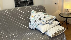 A room with a polka dot sofa, a door with a handle, and a small table with a lamp.
