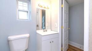 Ein kleines Badezimmer mit Toilette, Waschbecken und Spiegel.