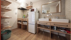 Een moderne keuken met houten planken, een koelkast, een spoelbak en een spiegel.