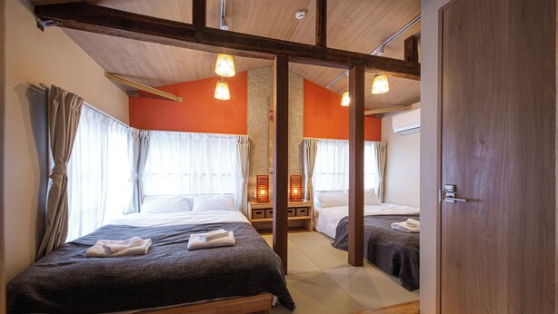 Een hotelkamer met twee bedden, houten balken en een grote spiegel.