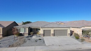 A residential house with a garage, a driveway, and a clear view of the surrounding landscape. - Airy Desert Getaway  (Indio)