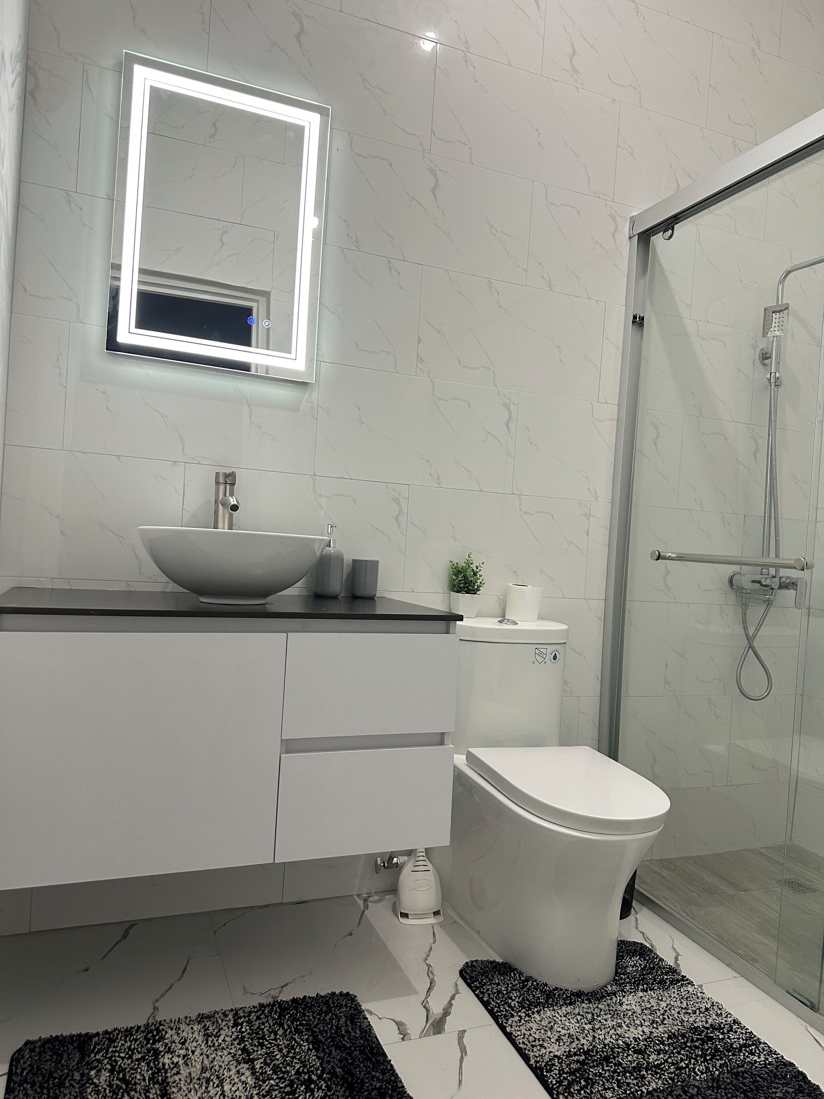 Een douche, handdoeken, zeep, toiletpapier