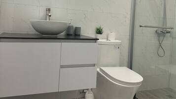 Een douche, handdoeken, zeep, toiletpapier