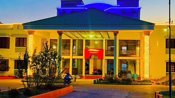 Un edificio con un letrero rojo que dice "Moorimgai Residency" y una entrada cubierta con columnas.