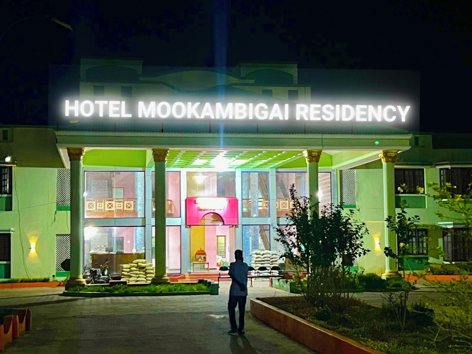 Hotel Mookambikai Residency with a prominent entrance and a person standing in front.