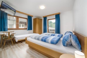 Quarto com cama, escrivaninha e cadeira.