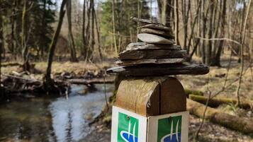 A wooden post with directional signs and a stack of stones.