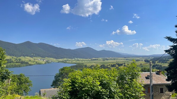 A view of a lake surrounded by mountains and greenery.