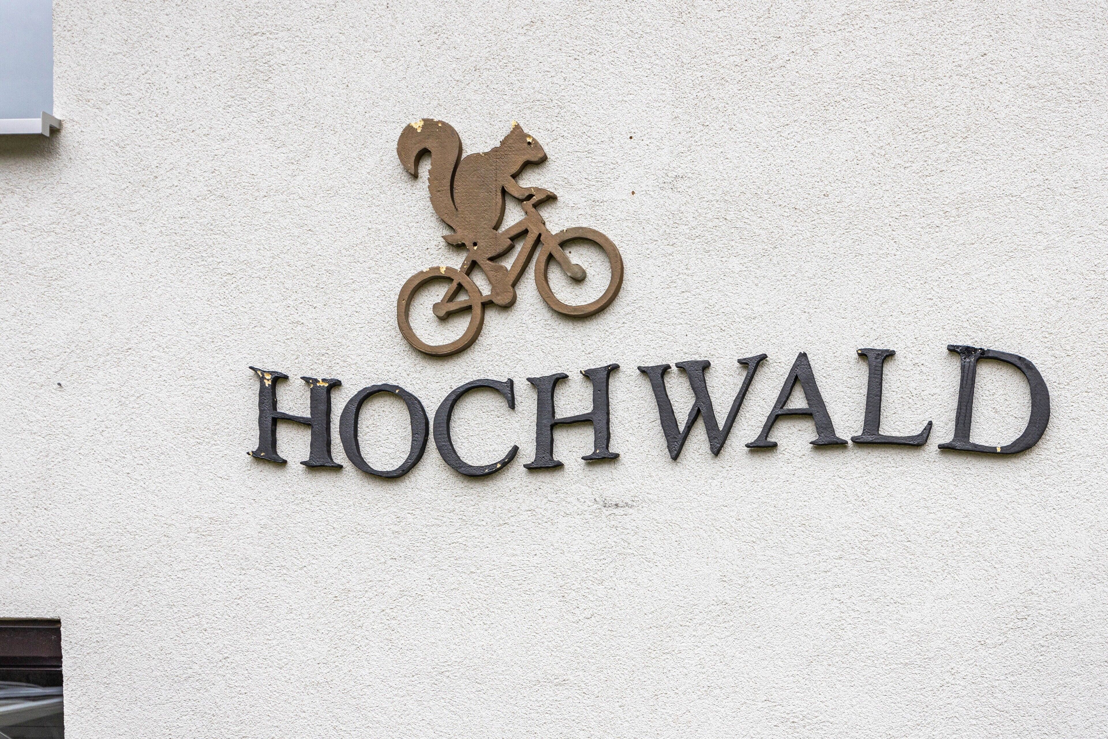 Ein Schild mit dem Schriftzug 'HOCHWALD' und einem Eichhörnchen auf einem Fahrrad.