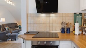 A modern kitchen with a flat-screen TV, a wooden countertop, and a built-in oven. - Holiday Apartment 'Kleinbreitenbach 2' with Mountain View and Wi-Fi (Plaue)