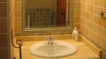 A bathroom with a sink, mirror, and tiled walls.