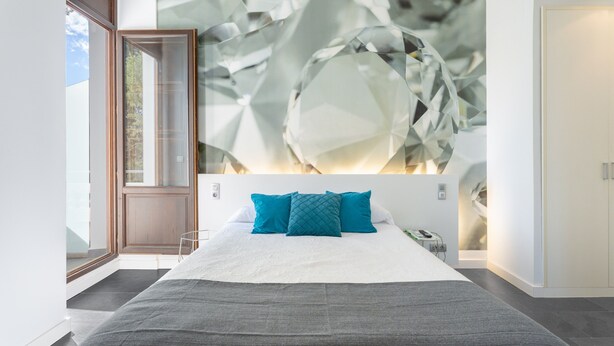 A modern bedroom with a large bed, a wall art piece, and a door leading to a balcony. - Room 'Esmeralda' with Mountain View, Wi-Fi and Air Conditioning (Navajas)