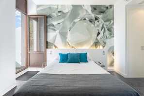 A modern bedroom with a large bed, a wall art piece, and a door leading to a balcony. - Room 'Esmeralda' with Mountain View, Wi-Fi and Air Conditioning (Navajas)