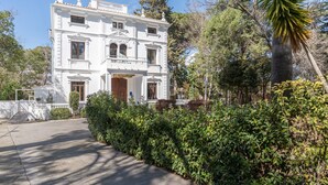 A white building with a symmetrical facade, large windows, and a central entrance. - Room 'Esmeralda' with Mountain View, Wi-Fi and Air Conditioning (Navajas)