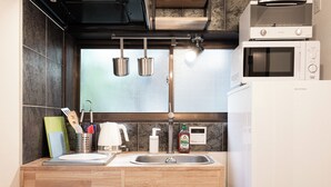 A kitchen with a double sink, stainless steel pots hanging from the ceiling, and a microwave oven. - EBISU BLUE Ebisu Station 8 min walk / Quiet residential area Ebisu is one of the most popular and elegant residential areas in Tokyo where everyone wants to live.  (渋谷区)
