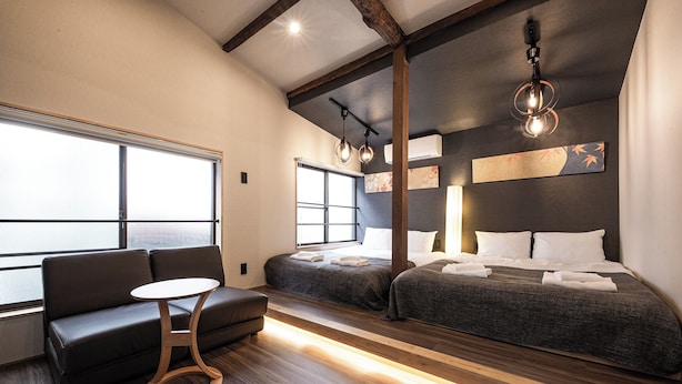 A modern hotel room with a large window, a sofa, a small table, and two beds. - EBISU BLUE Ebisu Station 8 min walk / Quiet residential area Ebisu is one of the most popular and elegant residential areas in Tokyo where everyone wants to live.  (渋谷区)