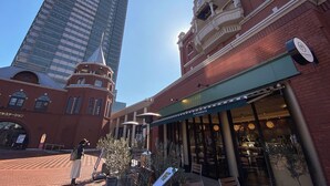 A building with a clock tower, a restaurant with outdoor seating, and a modern glass skyscraper in the background. - EBISU BLUE Ebisu Station 8 min walk / Quiet residential area Ebisu is one of the most popular and elegant residential areas in Tokyo where everyone wants to live.  (渋谷区)