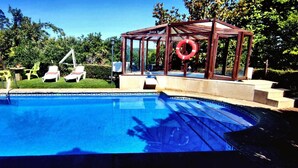 A swimming pool with lounge chairs and a gazebo. - Apartment 'Casa Rural Os Carballos' with Private Pool, Wi-Fi and Air Conditioning (Pontevedra)