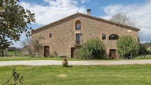 A stone building with a central balcony, a door, and a window.