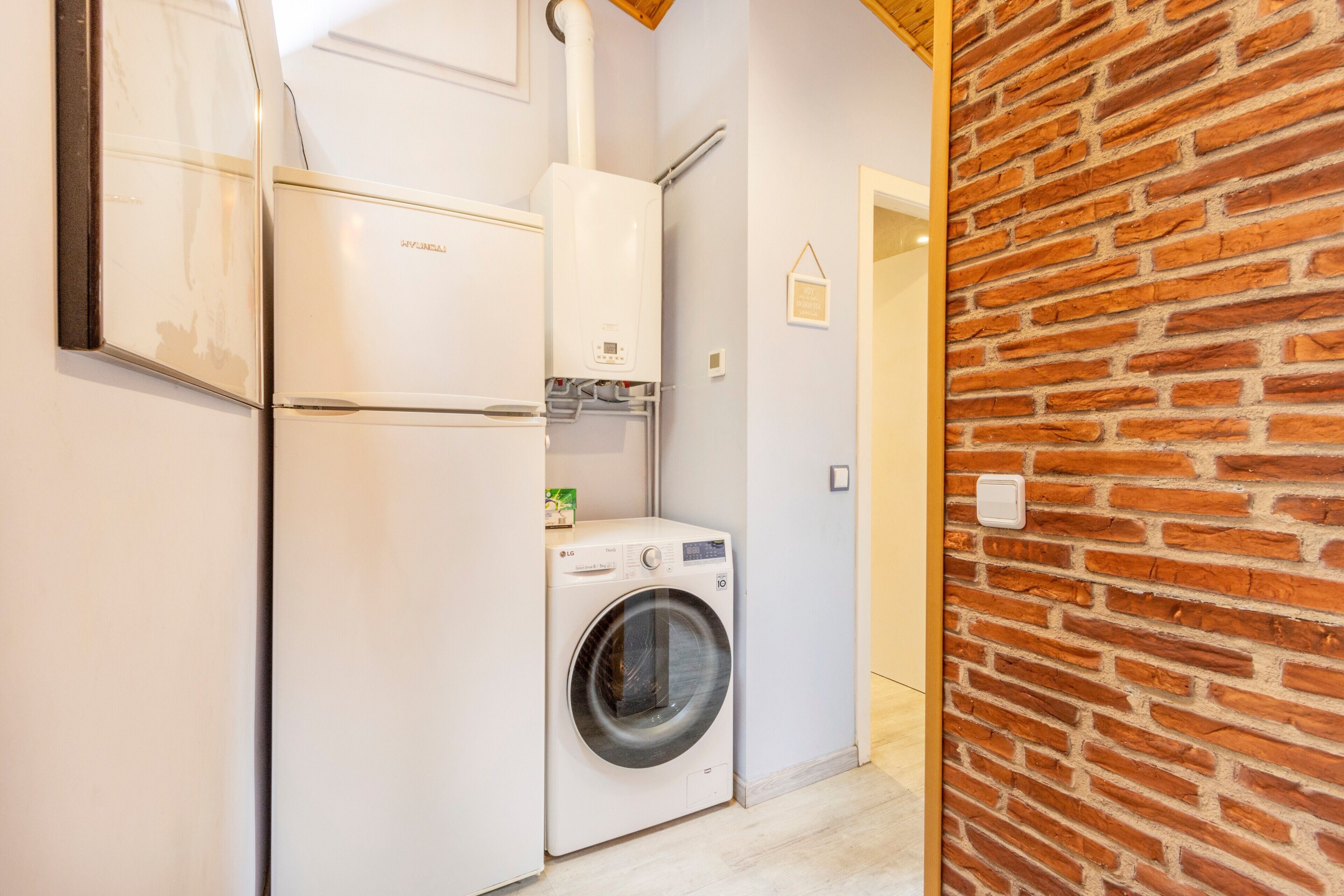 A compact laundry area with a washing machine, a dryer, and a water heater.